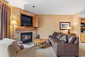 A living room with a fireplace, a television, a sofa, and a coffee table.