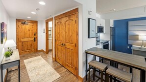 Una cocina moderna con puertas de madera, una zona de comedor con un banco y una pared azul de acento.