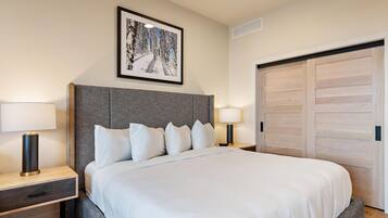 Een netjes ingerichte hotelkamer met een groot bed, twee nachtkastjes en een ingelijst schilderij aan de muur.