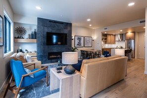 Un salon moderne avec une cheminée, un téléviseur et un coin repas.
