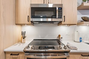 A kitchen with a stainless steel microwave, a gas stove, and a built-in oven.
