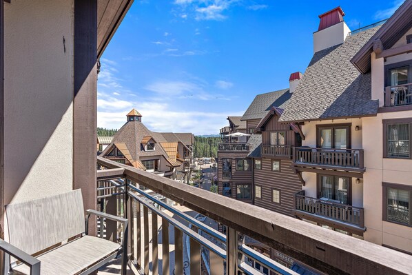A balcony with a view of a town center, featuring traditional architecture and a clear sky.