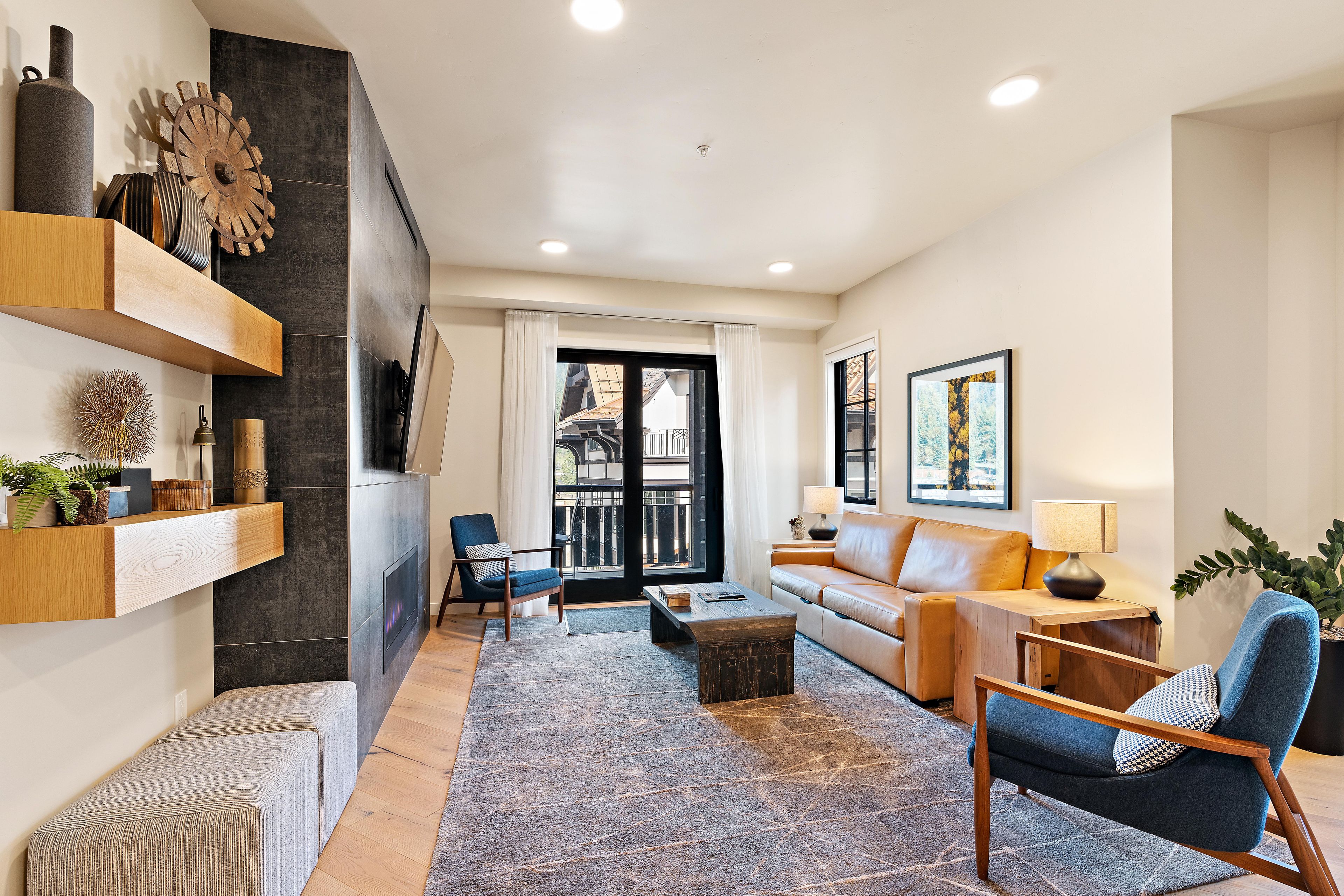 A modern living room with a fireplace, sofa, coffee table, and decorative items.