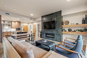 A modern living room with a fireplace, a dining area, and a kitchen. - First Chair Lair | Includes Two 1-Day Lift Tickets (Tamarack)