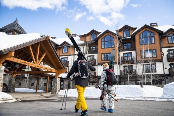 A lodge with a wooden facade, multiple balconies, and a sign reading "The Lodge at Osprey Meadows."