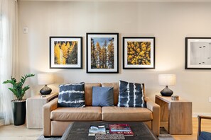 A living room with a sofa, two side tables, a coffee table, and three framed pictures on the wall. - Happy Aspen | Includes Two 1-Day Lift Tickets (Tamarack)