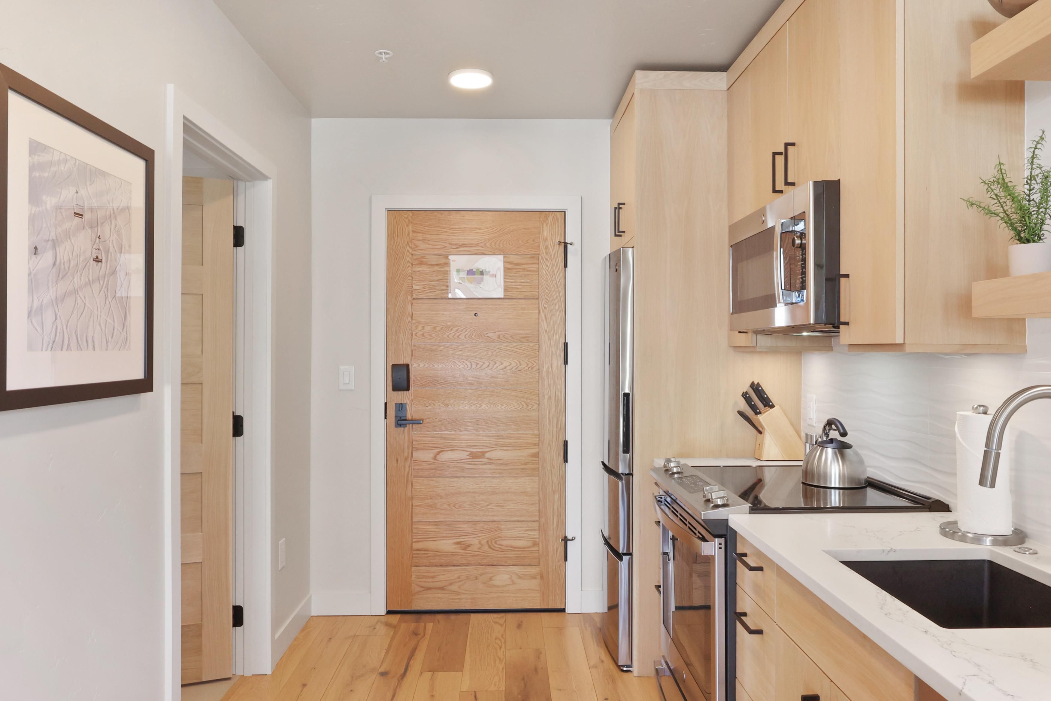 Una cocina moderna con armarios de madera, electrodomésticos de acero inoxidable y encimera de mármol.