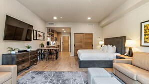 Ein modernes Hotelzimmer mit Bett, Sofa und Essecke.
