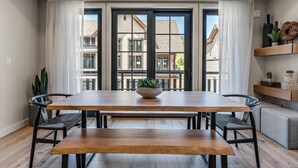 A dining area with a wooden table, two chairs, a bench, and a potted plant. - Sassafras Suite | Includes Two 1-Day Lift Tickets (Tamarack)