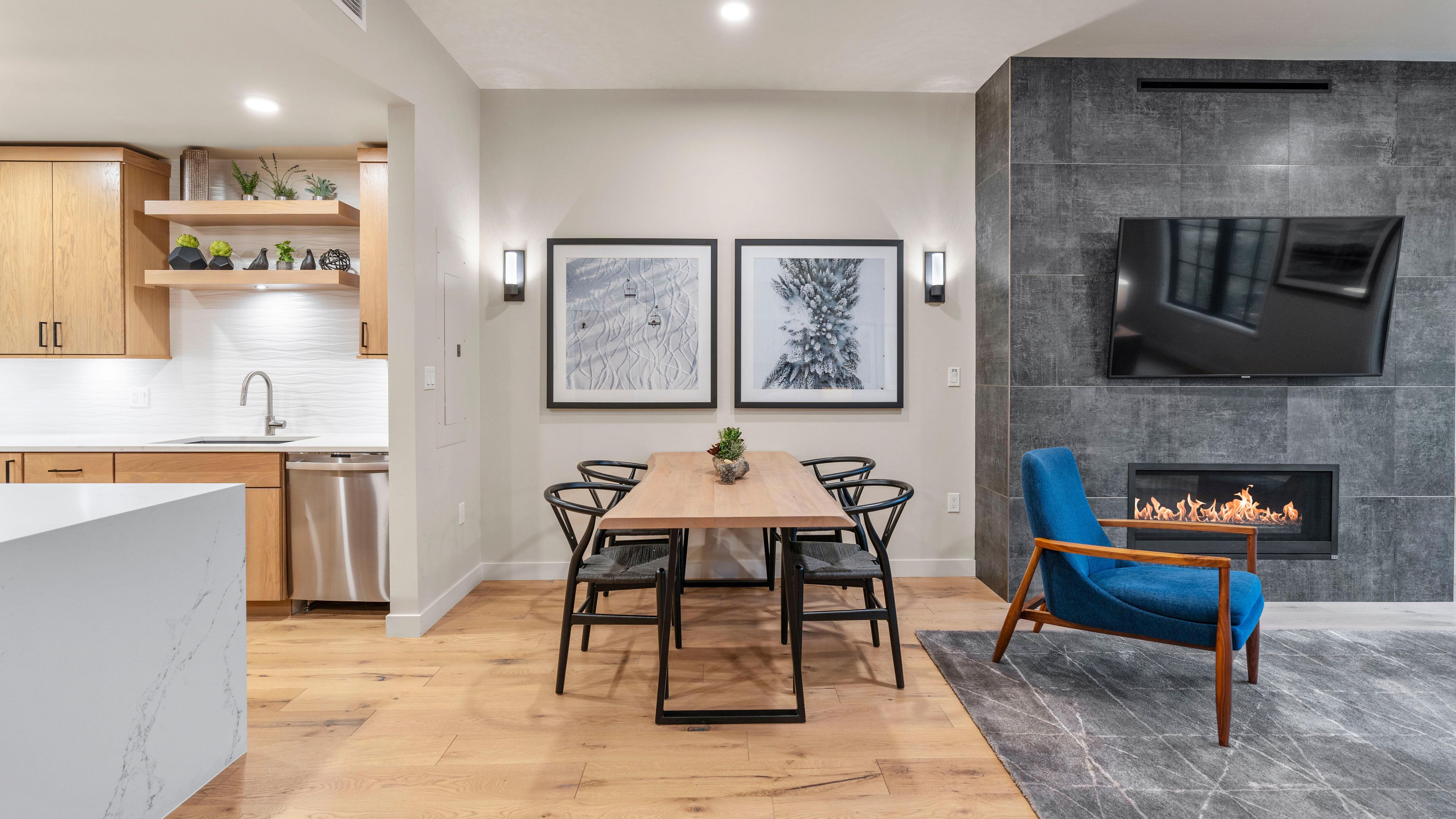 A modern kitchen with wooden cabinets, a stainless steel dishwasher, and a marble countertop.