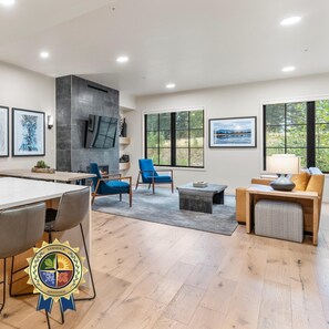 A modern living room with a fireplace, seating area, and large windows. - Mountain Condo | Includes Two 1-Day Lift Tickets (Tamarack)