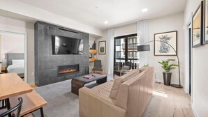 Una sala de estar moderna con chimenea, un sofá, una mesa de centro y un televisor.