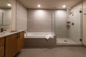 Une salle de bain moderne avec une baignoire, une douche à parois de verre et des meubles en bois.