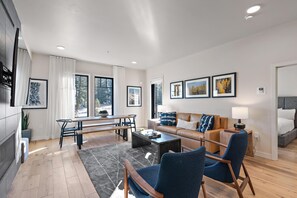 A modern living room with a sofa, chairs, a coffee table, and artwork on the walls.