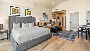 Een moderne hotelkamer met een groot bed, een zithoek en een kitchenette.