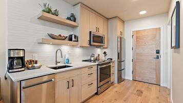 A modern kitchen with wooden cabinets, stainless steel appliances, and a built-in oven.