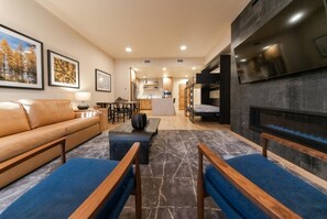 Un salon moderne avec un canapé, une table basse et une cheminée.