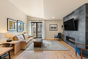 A modern living room with a sofa, coffee table, and a fireplace. - Cloudline | Includes Two 1-Day Lift Tickets (Tamarack)
