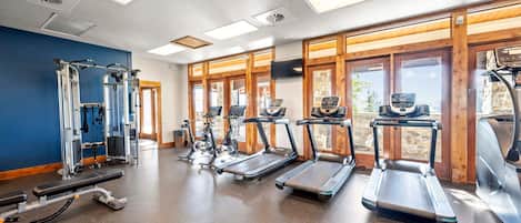 A gym with treadmills, elliptical machines, and weightlifting equipment.