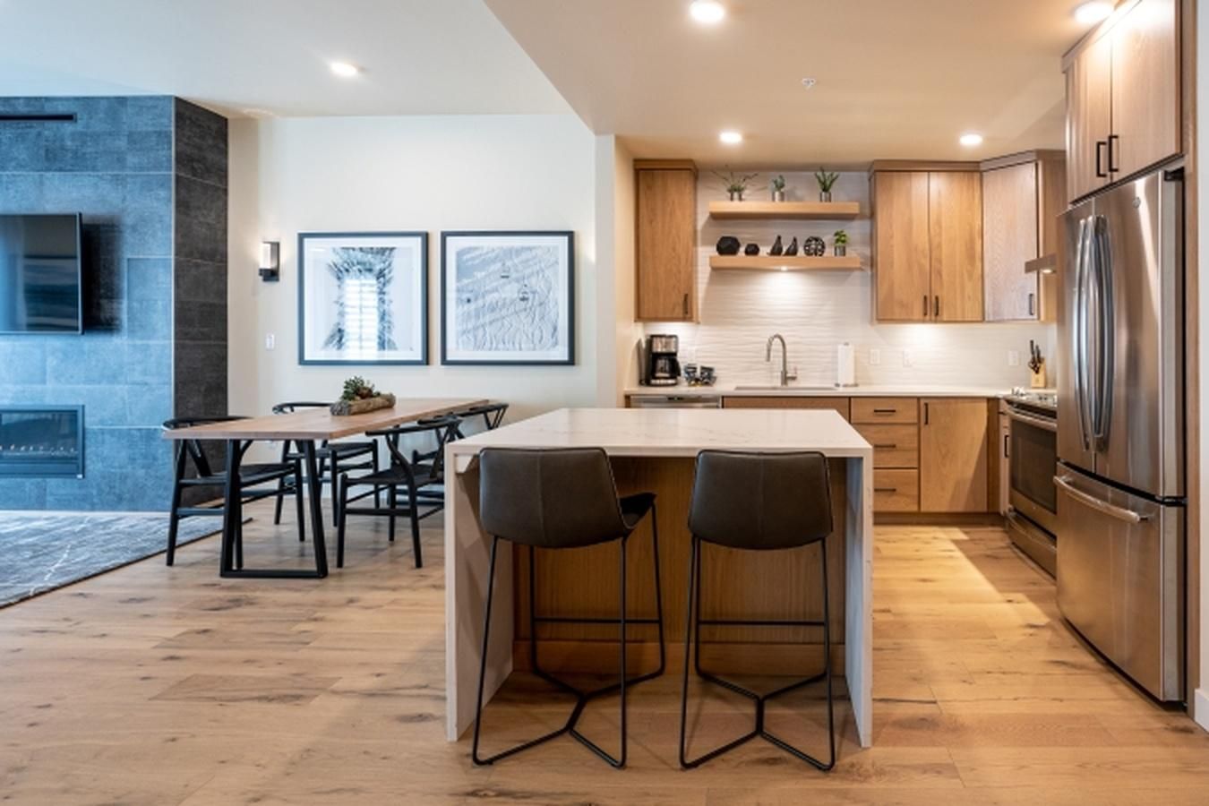 Una cocina moderna con una isla central, armarios de madera y electrodomésticos de acero inoxidable.