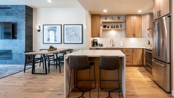 Una cocina moderna con una isla central, armarios de madera y electrodomésticos de acero inoxidable.