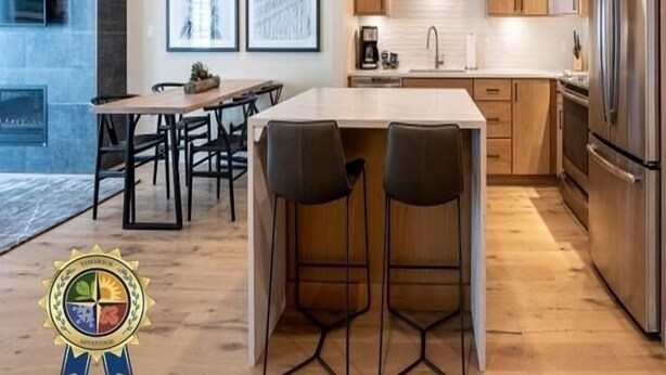 A modern kitchen with a central island, wooden cabinets, and stainless steel appliances. - Wind-Walker | Includes Two 1-Day Lift Tickets (Tamarack)