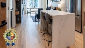 A modern kitchen with a central island, wooden cabinets, and a stainless steel refrigerator. - Western Grebe | Includes Two 1-Day Lift Tickets (Tamarack)