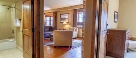 Una habitación amplia con piso de madera, un ventanal y vistas al exterior.
