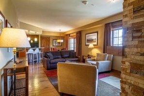 Un salon comprenant un canapé, des fauteuils, une table basse et un coin repas avec des chaises et une table.