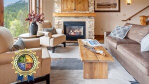 Una sala de estar acogedora con chimenea de piedra, asientos cómodos y vistas al exterior.