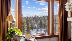 Una habitación con un ventanal grande que da a un bosque nevado.