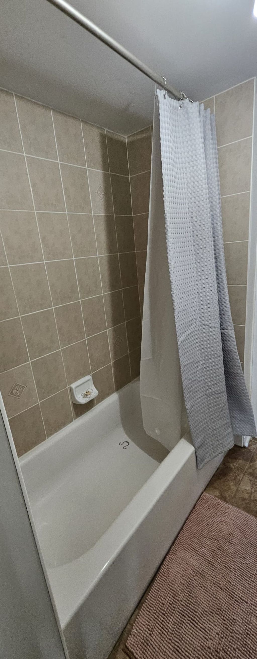 Eine Dusche mit Glastür und einem Handtuch an der Wand.