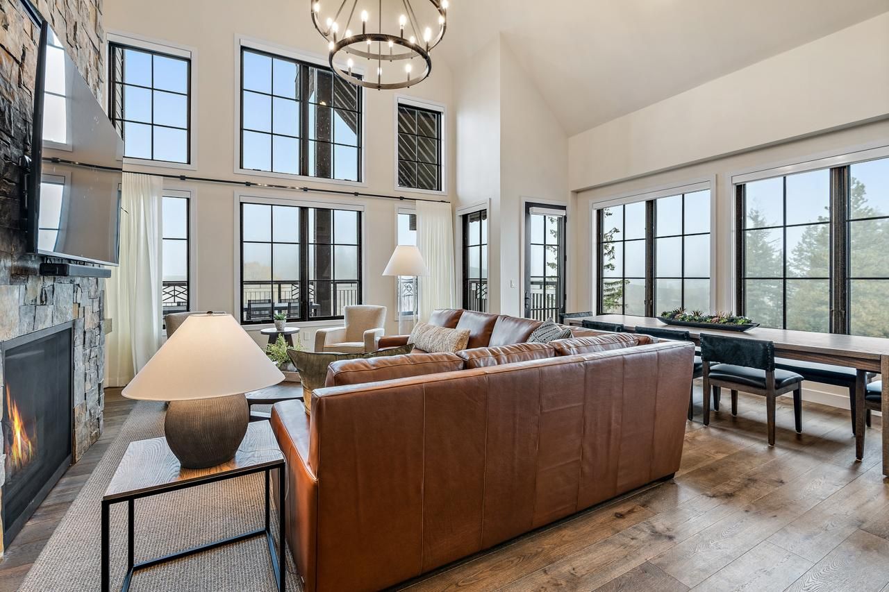 A spacious living area with a large leather sofa, a fireplace, and a dining table.