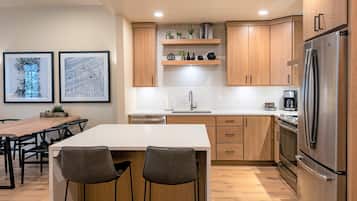 Een moderne keuken met houten kastjes, een roestvrijstalen koelkast en een wit aanrecht.