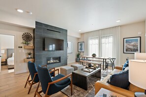 Una sala moderna con chimenea, zona de estar y comedor.