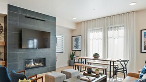 Una sala moderna con chimenea, comedor y sofá.