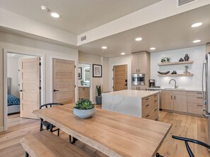 A modern kitchen with a central island, wooden cabinetry, and built-in appliances. - Game Crossing | Includes Two 1-Day Lift Tickets (Tamarack)