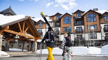 A lodge with a wooden facade, multiple balconies, and a sign reading "The Lodge at Osprey Meadows."