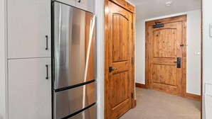 A kitchen with stainless steel appliances and wooden doors. - Bear Den | Includes Two 1-Day Lift Tickets (Tamarack)