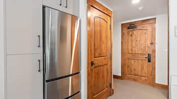 A kitchen with stainless steel appliances and wooden doors.