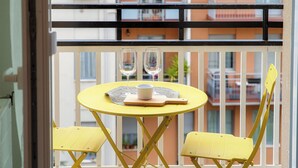 A yellow table with two glasses and a cup on a balcony with yellow chairs. - Luci A Lago (Como)