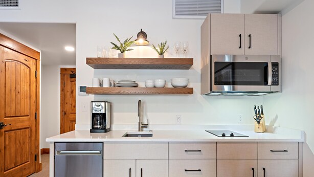 Une cuisine moderne avec des meubles en bois, un four à micro-ondes en acier inoxydable et un lave-vaisselle encastré.