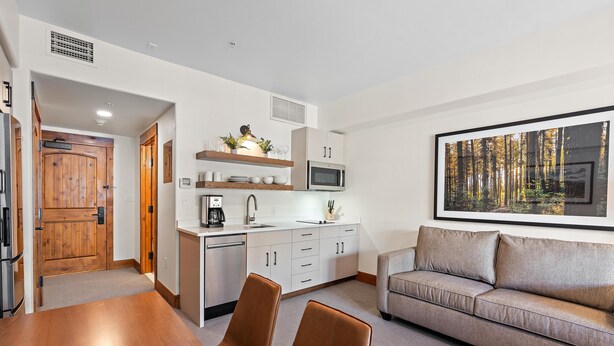 A modern kitchen with white cabinets, a built-in microwave, and a coffee maker. - Happy Loon | Includes Two 1-Day Lift Tickets (Tamarack)