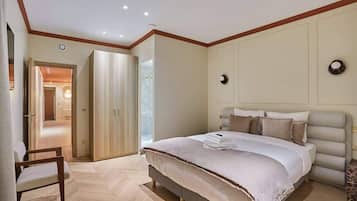 Une chambre avec un grand lit, une chaise et une armoire.