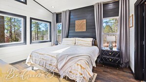 A bedroom with a large bed, a nightstand, and a window with curtains. - Game-Filled Retreat for Families and Friends (Broken Bow)