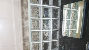 A bathroom with a glass partition, a white sink, a mirror, and a toilet. - Accommodation London Bridge (London)