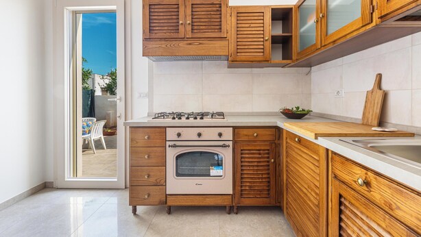 A kitchen with wooden cabinets, a built-in oven, and a countertop. - 3882 Residenza Virginia by Barbarhouse (Tricase)
