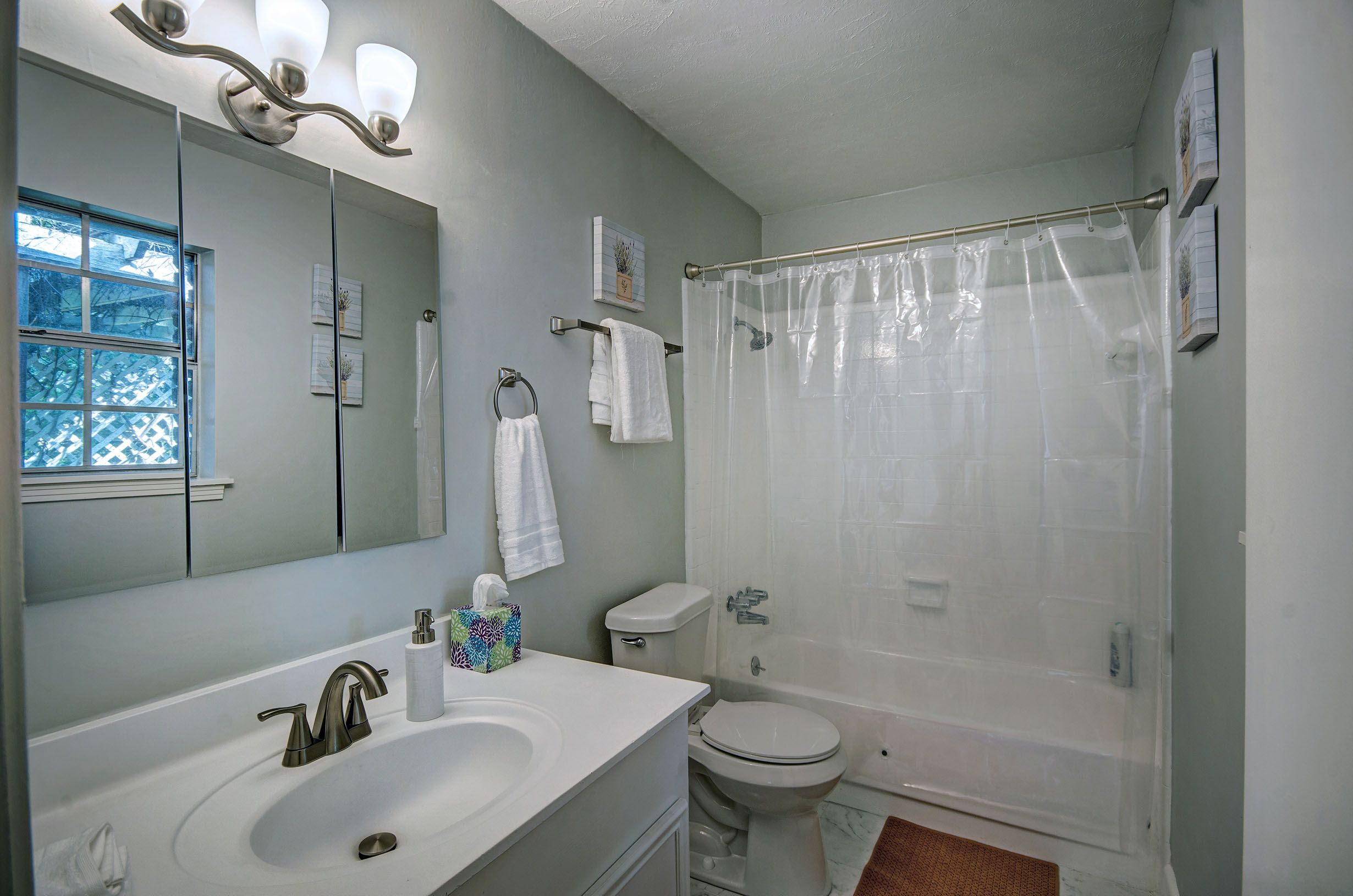 A bathroom with a sink, toilet, and shower.