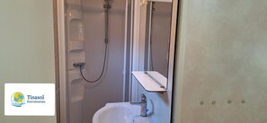 A bathroom with a shower, a sink, and a mirror.