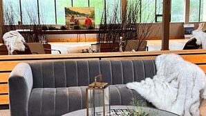 A modern living room with a grey sofa, a round coffee table with a lantern, and a white fluffy throw. - Nomi - 305 Queen Studio (Family Room) (Harcourt)